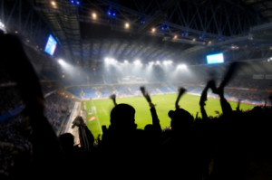 Silhouettes of fans celebrating a goal on football / soccer match